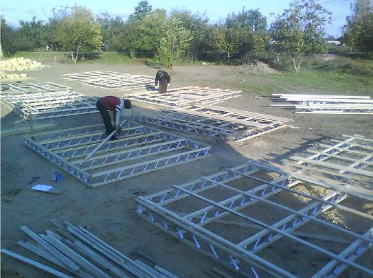 02 sandbag house1.jpg - Workers begin preparation of the wooden frames used to construct buildings designed according to the principles of Maharishi Vedic Architecture, or Vastu. The frames are similar to traditional post and beam construction, but they will be filled with a revolutionary type of green insulation: sand.